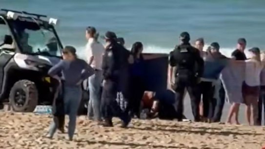 A woman is treated on Coogee Beach after being bitten by a shark.