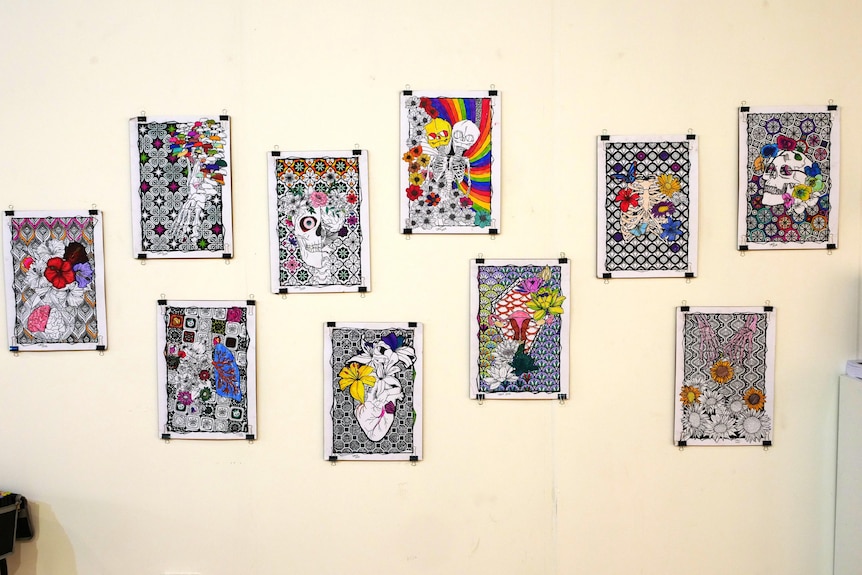 colourful colouring book pages pinned on a wall.