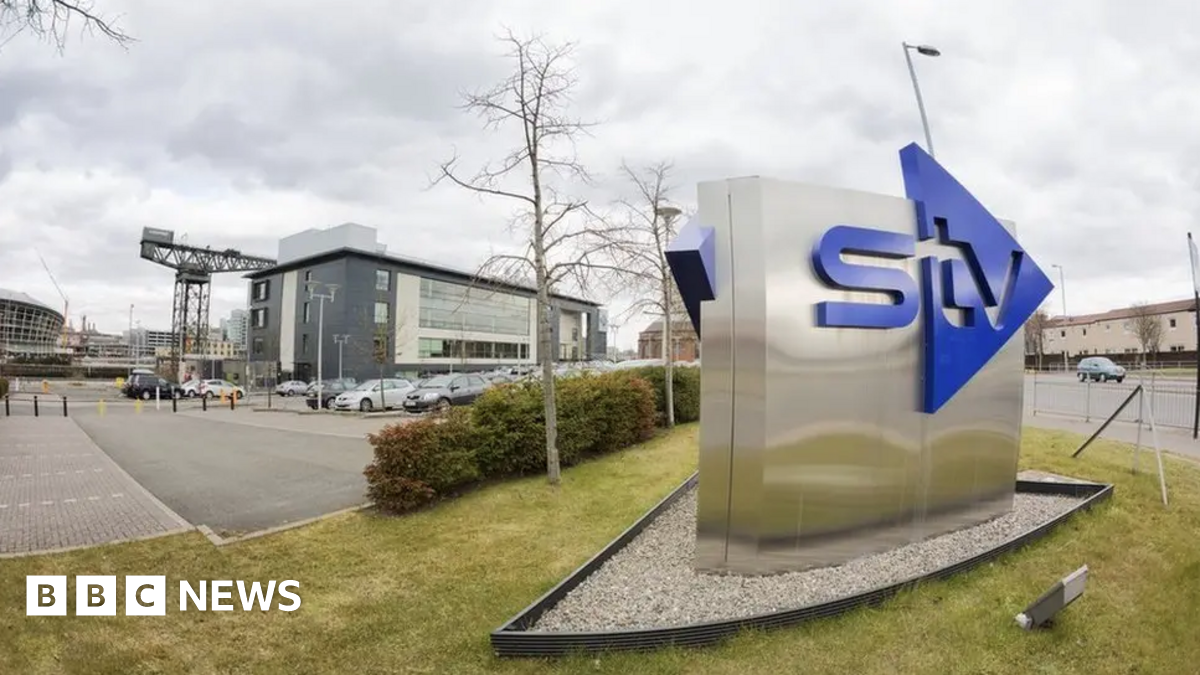 An STV sign outside the HQ building in Glasgow with the Finnieston Crane and the Hydro in the background