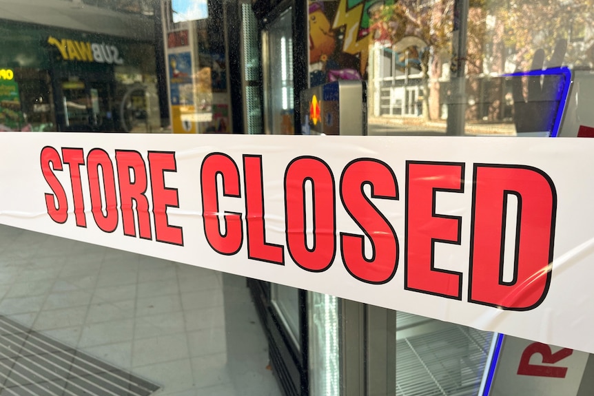 Shop with glass doors covered in large Store Closed signs