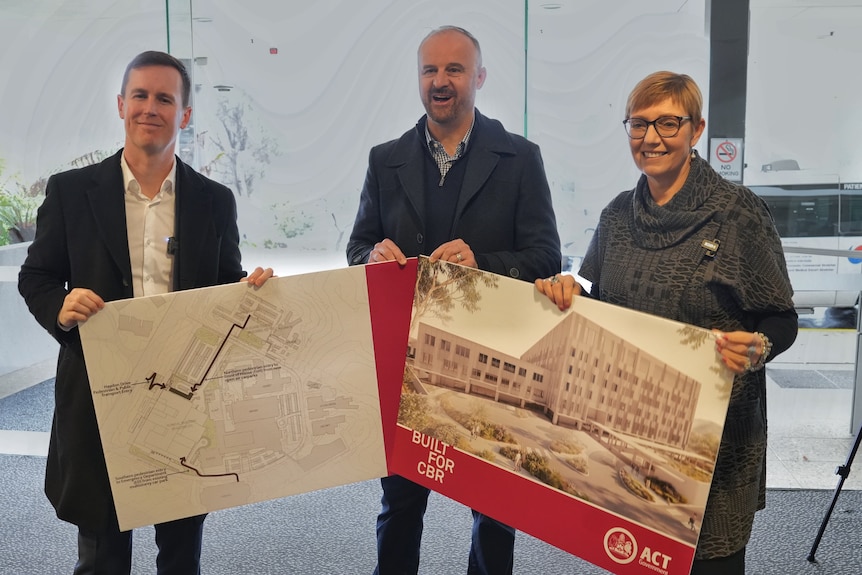 Chris Steel, Andrew Barr and Rachel Stephen-Smith holding images of a building design.
