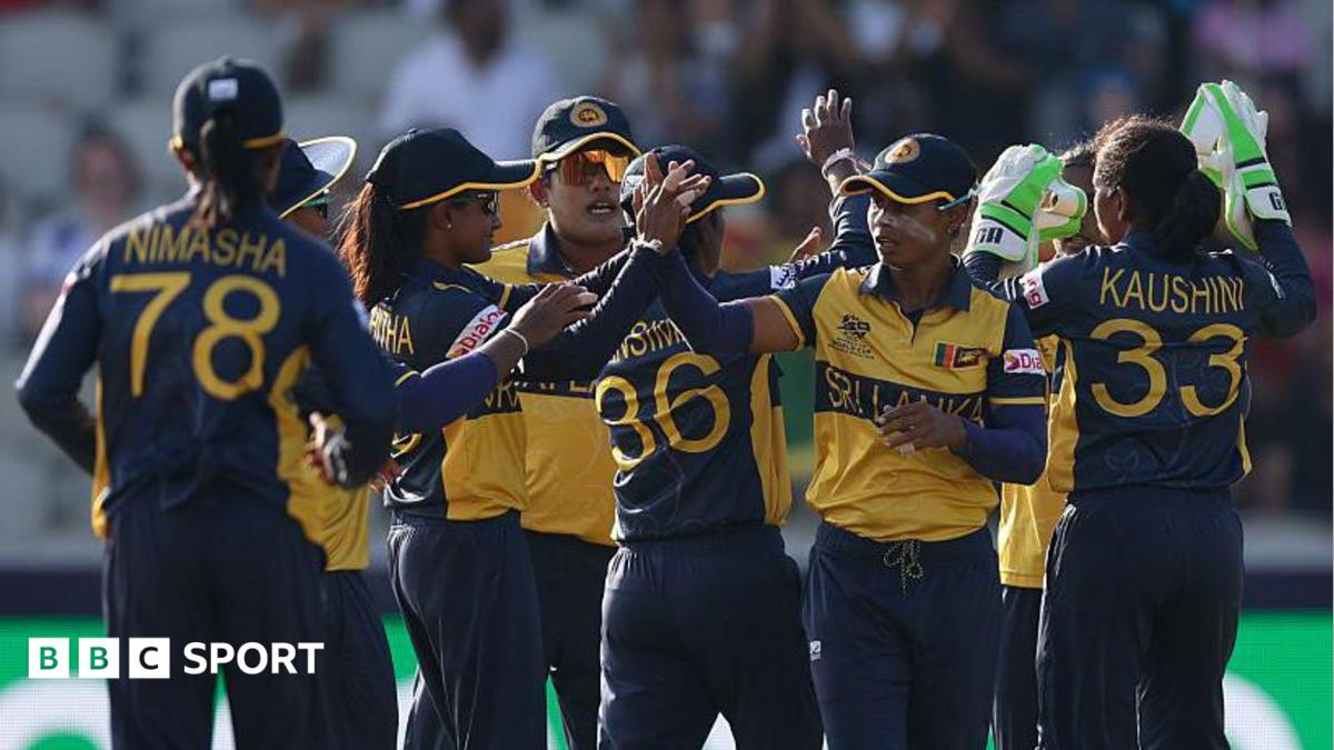 Sri Lanka's players, wearing dark blue and yellow shirts and blue trousers, exchange high fives to celebrate a wicket