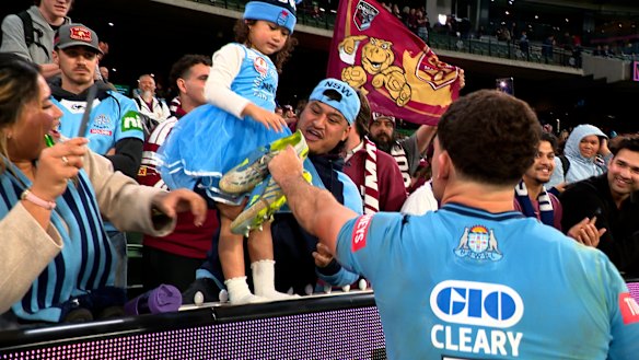 Nathan Cleary hands his boots to a young fan after Origin II.