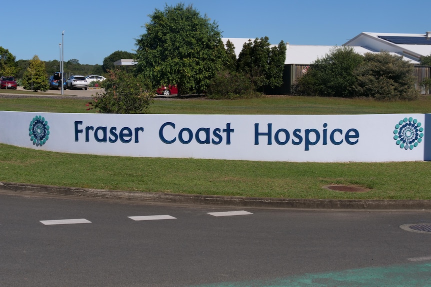 A large sign for a hospice facility stands in front of the service.