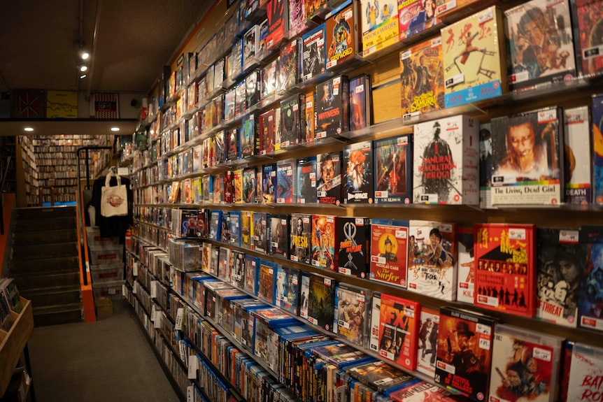 Dozens of DVDs on wall display in a Melbourne store.