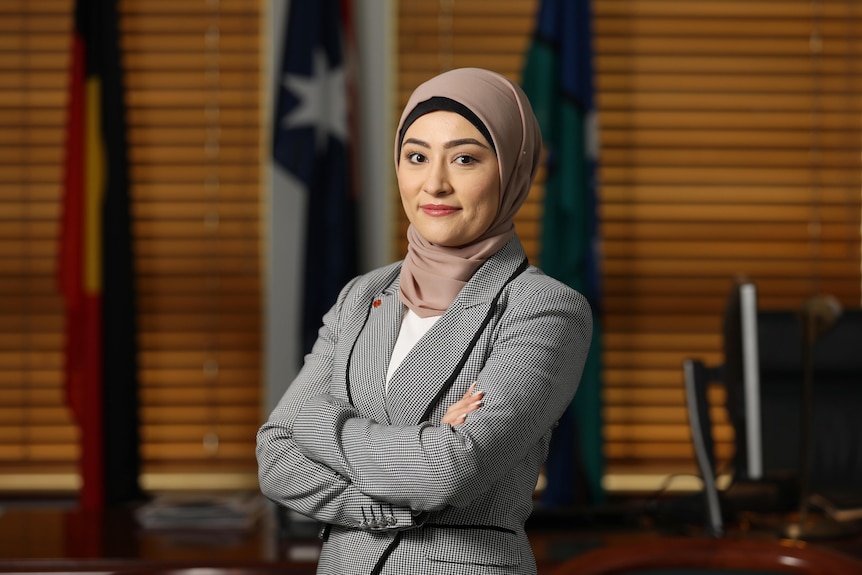 Fatima Payman stands with her arms crossed inside her Parliament House office
