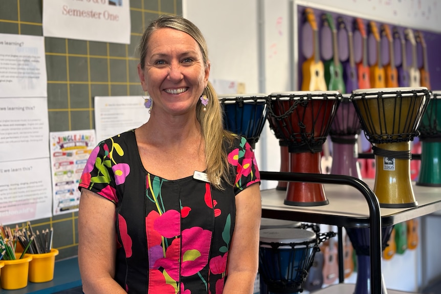 A woman smiles with instruments behind her