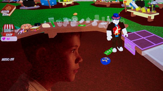 In a multiple exposure image, a 10-year-old Sydney boy looks at a game hosted on the Roblox platform.