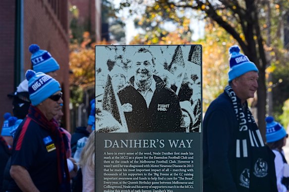 Spectators pass a sign in honour of Daniher during the Walk to the G ahead of Monday’s game.