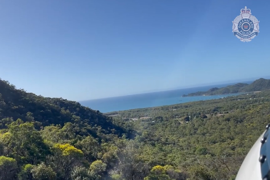 A photo from onboard a helicopter flying over an island.