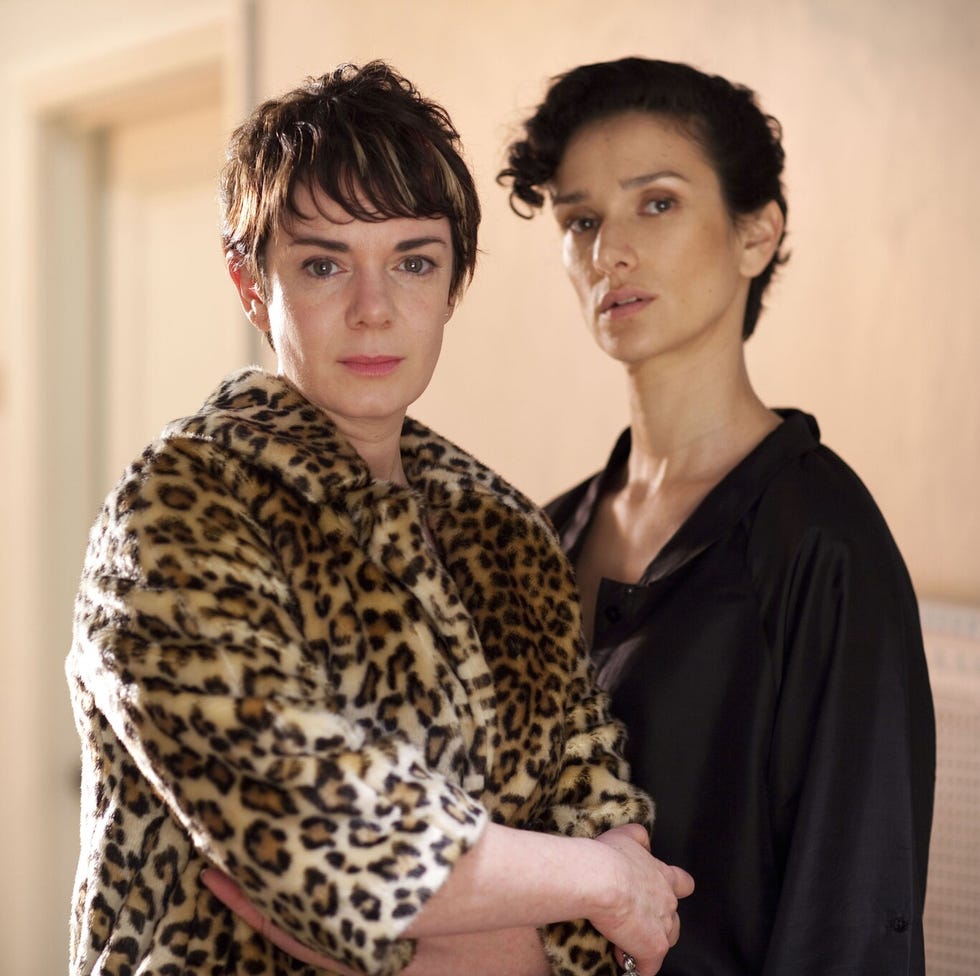 two individuals standing closely together one wearing a leopard print coat two individuals standing closely together one wearing a leopard print coat
