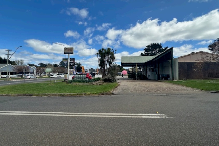 Side view of single-storey shop with pink potato in background