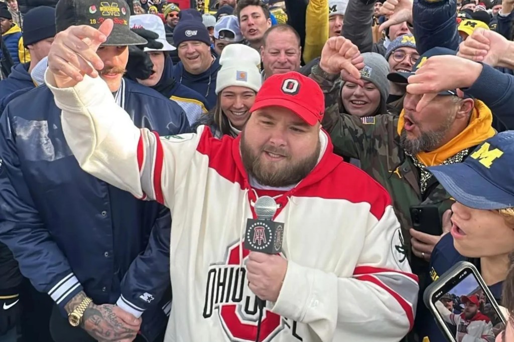 Big Ev from Barstool Sports speaking into a microphone, surrounded by a crowd.