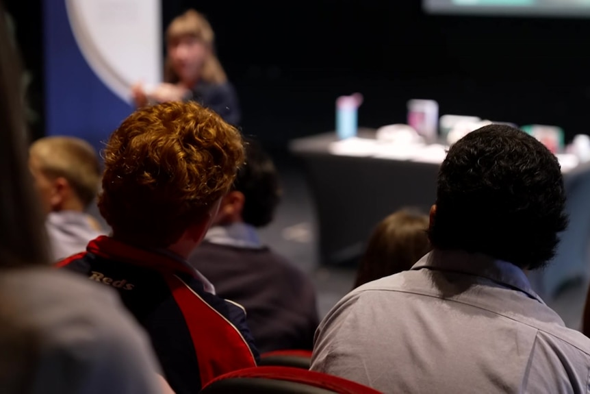 The back of the heads of two boys listening to a lecture