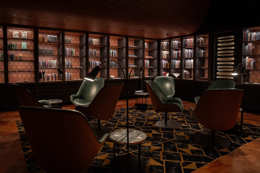 Chairs, lamps and tables in a dark reading room of a library.