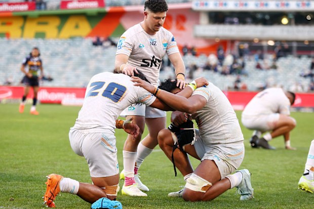 Moana Pasifika players pray after winning the round 16 Super Rugby match.