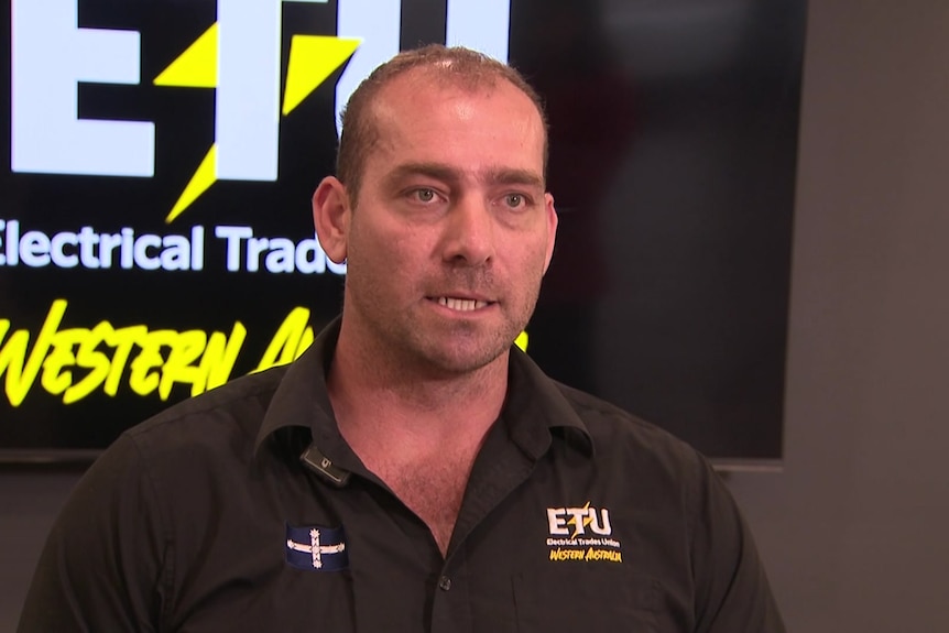 Electrical Trades Union WA state secretary Adam Woodage speaks wearing an ETU polo shirt, black.