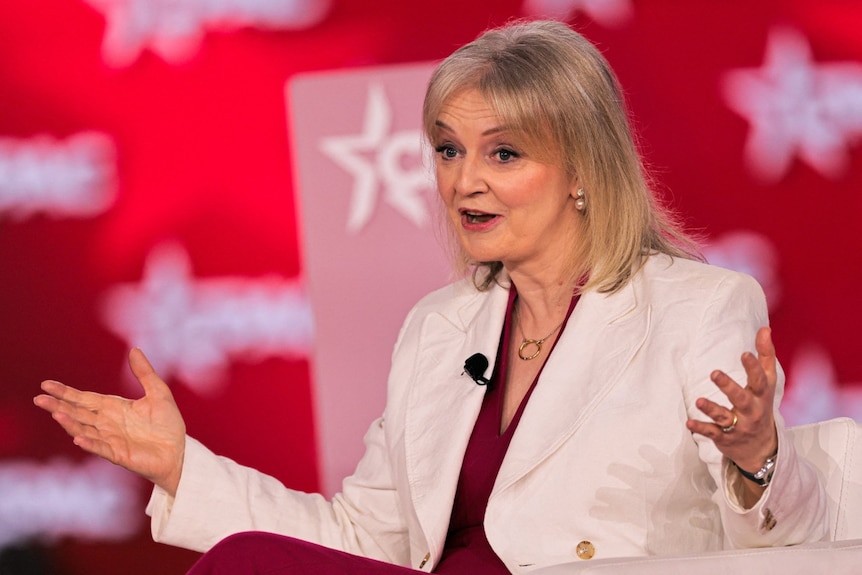 Liz Truss gestures with her hands as she speaks.