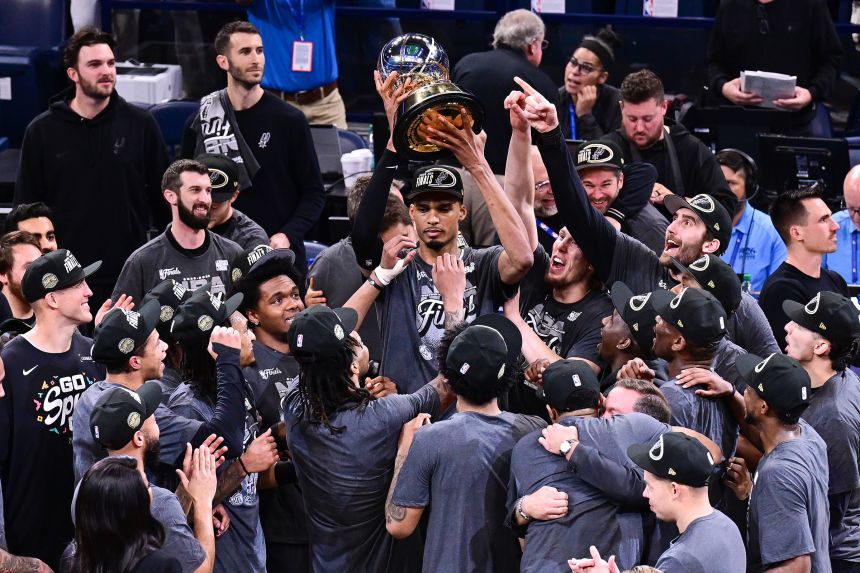 Victor Wembanyama hoists the Oscar Robertson Trophy with his teammates after defeating the Oklahoma City Thunder in Game 7 of the NBA's Western Conference Finals in May.