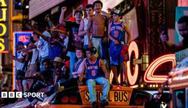 Fans in New York celebrate on top of a school bus