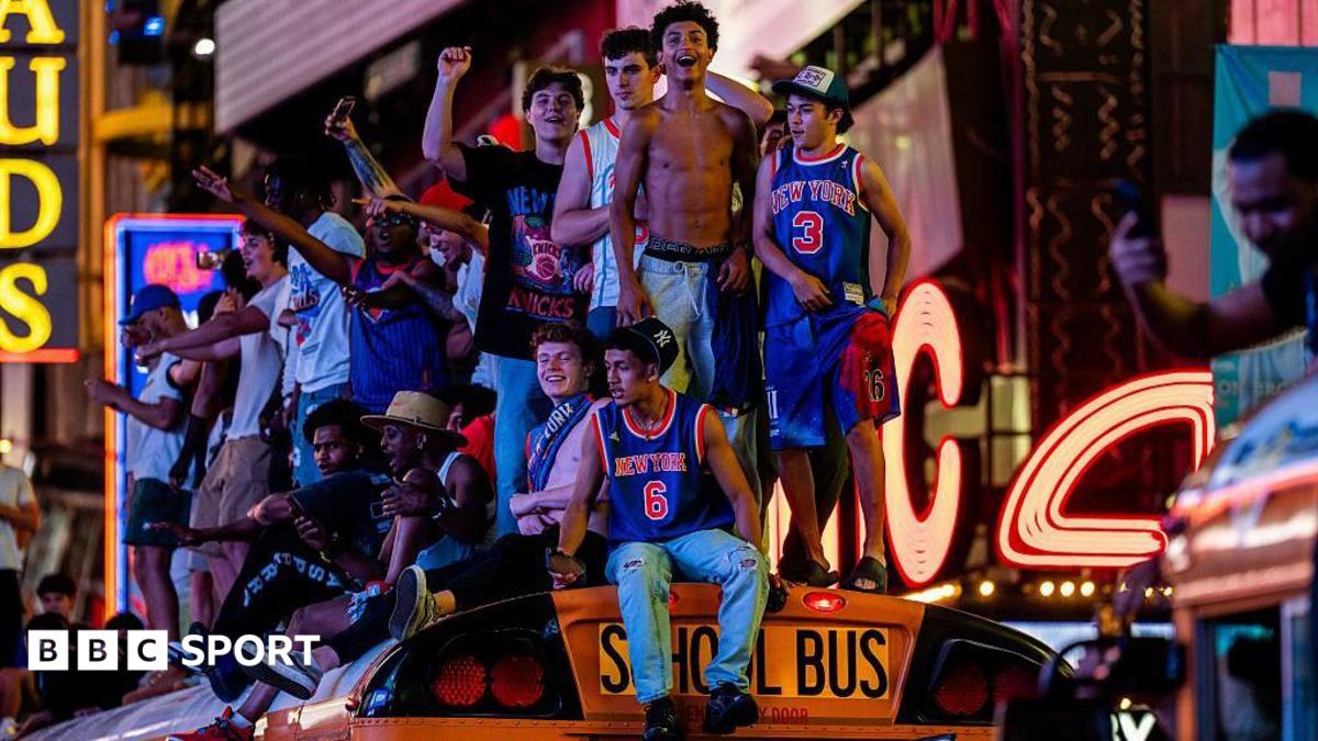 Fans in New York celebrate on top of a school bus