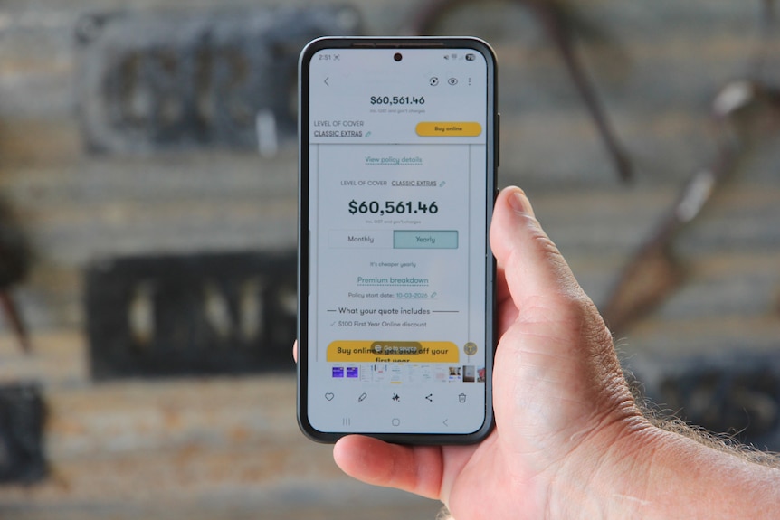 a hand holding a phone with a quote for $60,561 on the screen