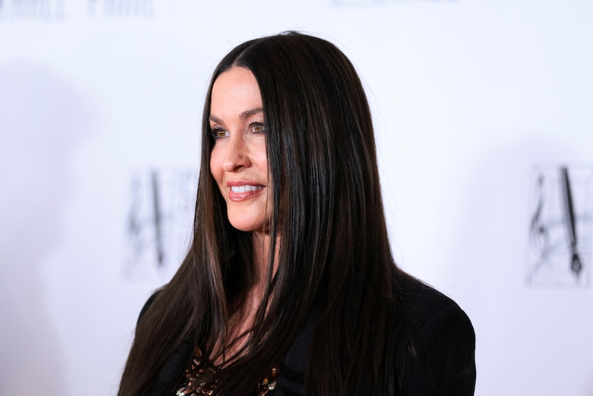 Alanis Morissette side profile looking off into the distance smiling