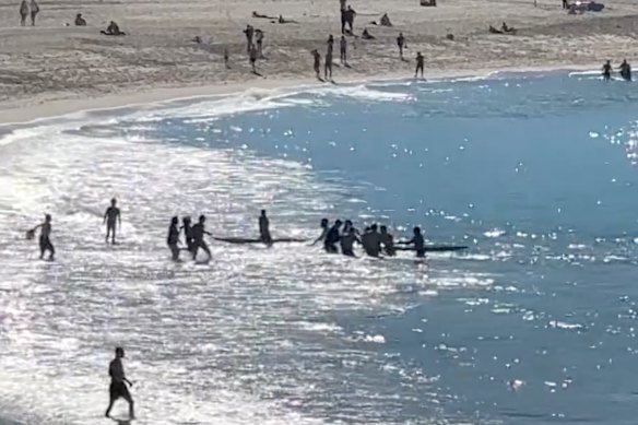 Charlie Verco and bystanders pull the woman from the water at Coogee.