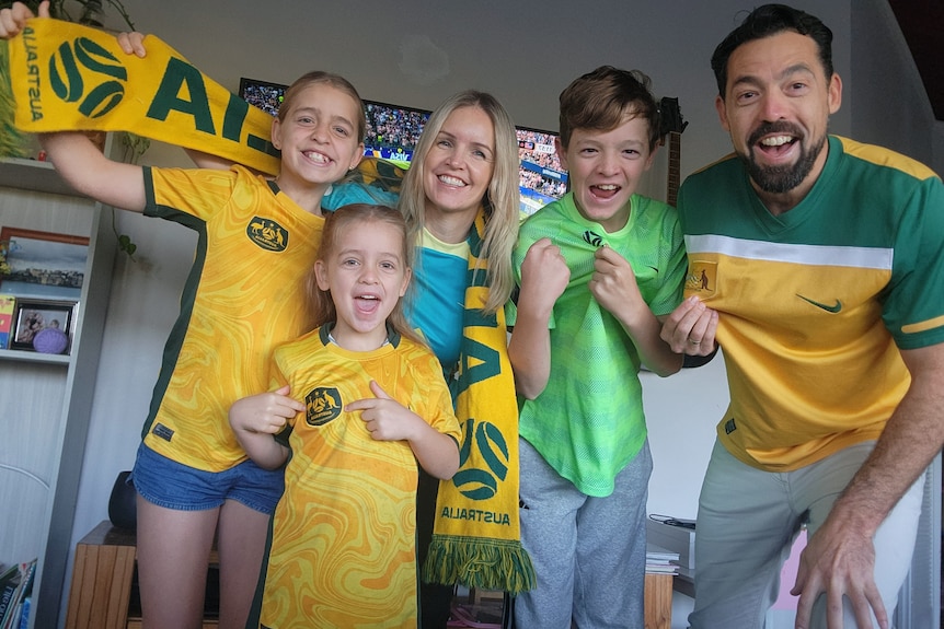 Doug Raisin, his wife and their three kids dressed in green and gold