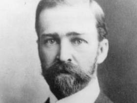 A black and white photo of a balding man