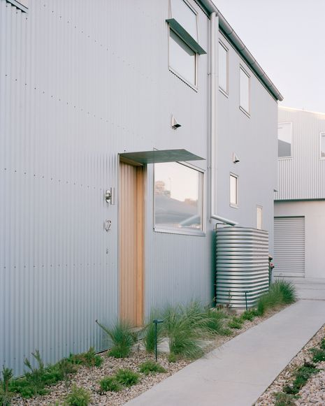 Hard paving is relegated to a single pathway, with an adjacent gravel track accommodating cars. This allows parking to be placed at the centre of the site, giving each dwelling either a generous front or back garden address.