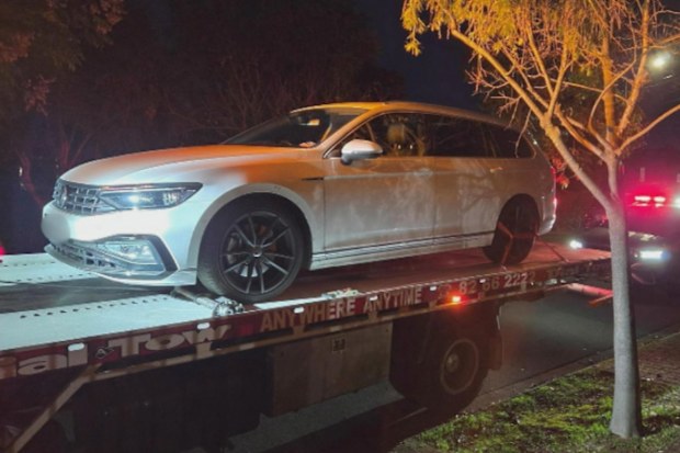 A white volkswagen being impounded at night.