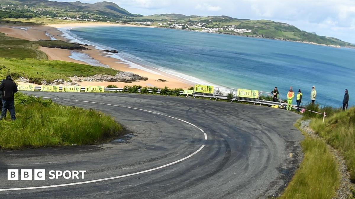 A corner of the track at the Donegal International Rally, overlooking a beach, with a handful of spectators standing behind the barrier