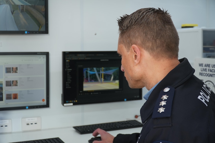 A police officer stares intently at a computer
