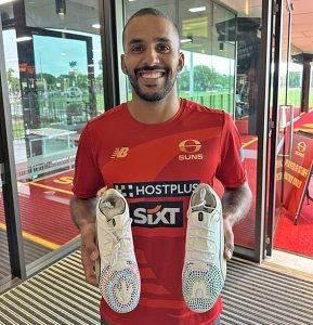 Gold Coast Suns vice-captain Touk Miller receives boots designed by an NPA State College student.
