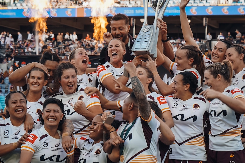 Brisbane Broncos celebrate with the NRLW premiership trophy after beating the Sydney Roosters in the grand final.
