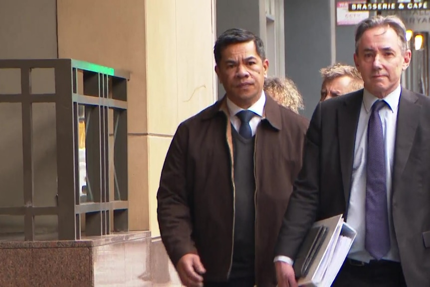 Two men wearing suits walking together.