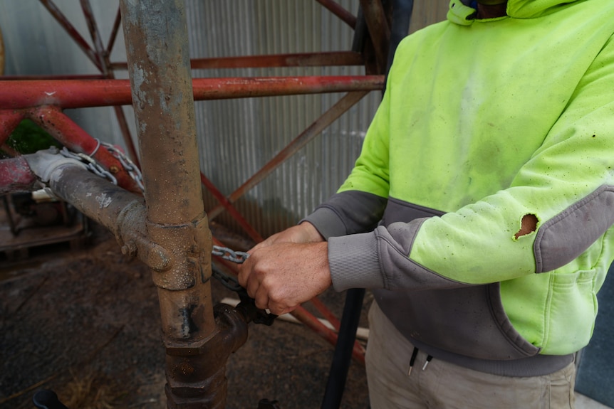 A man locks a padlock protecting diesel tanks.