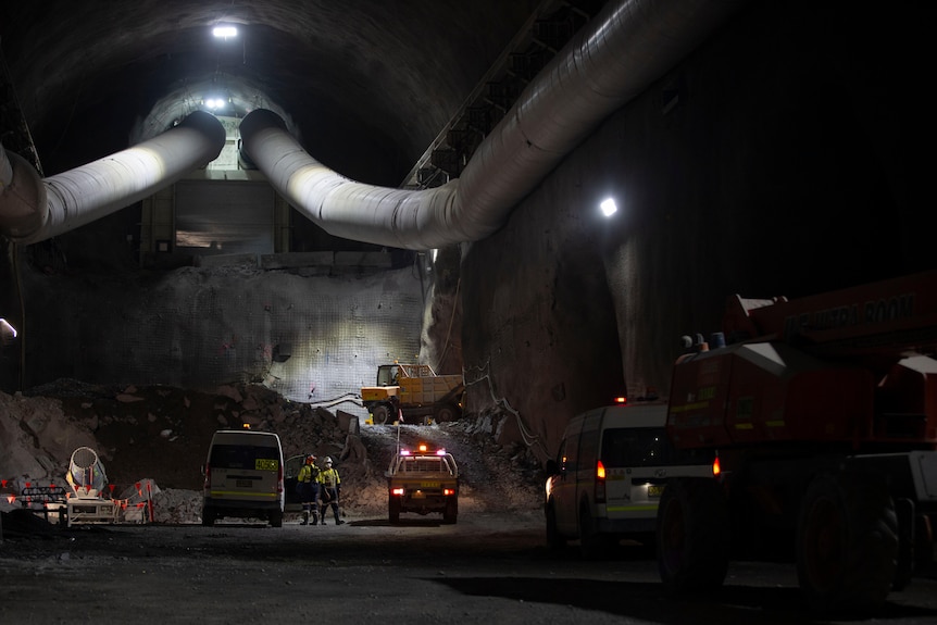 a tunnel with vehicles and workers inside