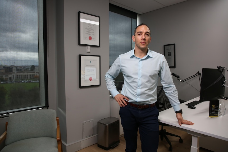 a man in a blue shirt inside an office.