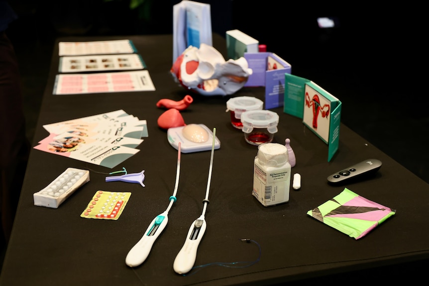 A range of items related to period pain and endometriosis on a black tabletop