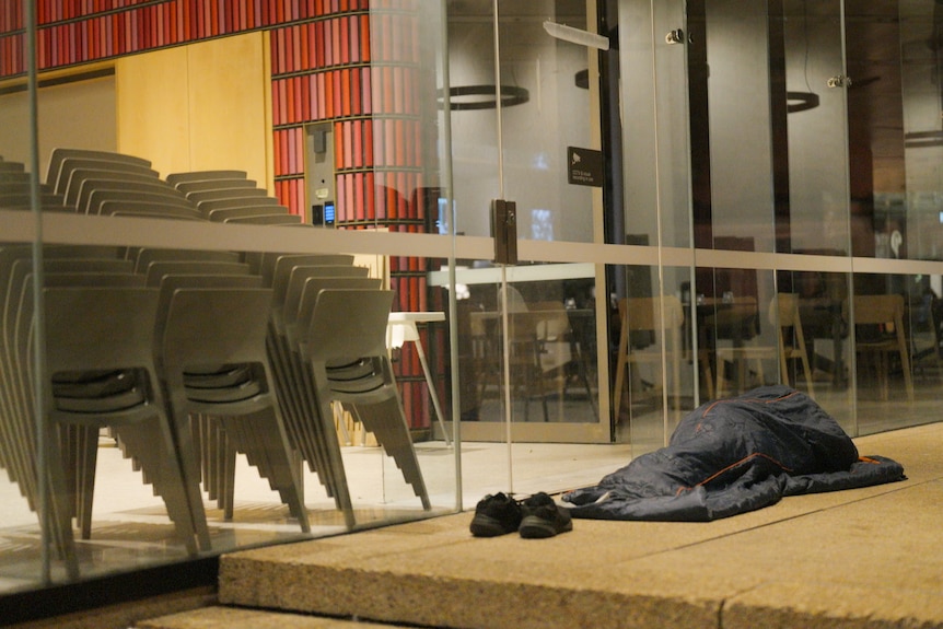 A person in a sleeping bag on a footpath in Sydney