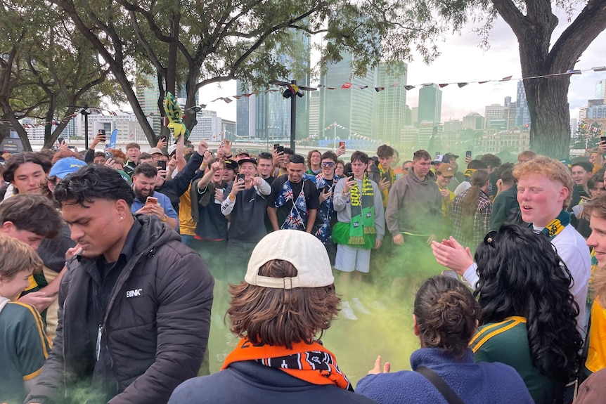 Group outside in green and gold with plume from green flare in air
