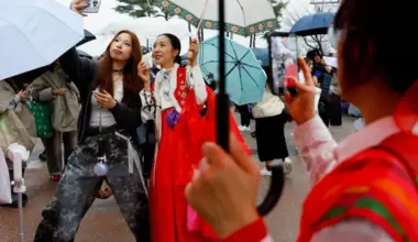A BTS fan wearing Korean traditional clothing Hanbok, takes a selfie ahead of the band's concert in Goyang, on April 9.