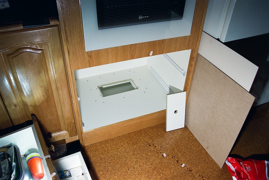 A cut-out at the bottom of a shelf underneath where two drawers sat in a kitchen. 