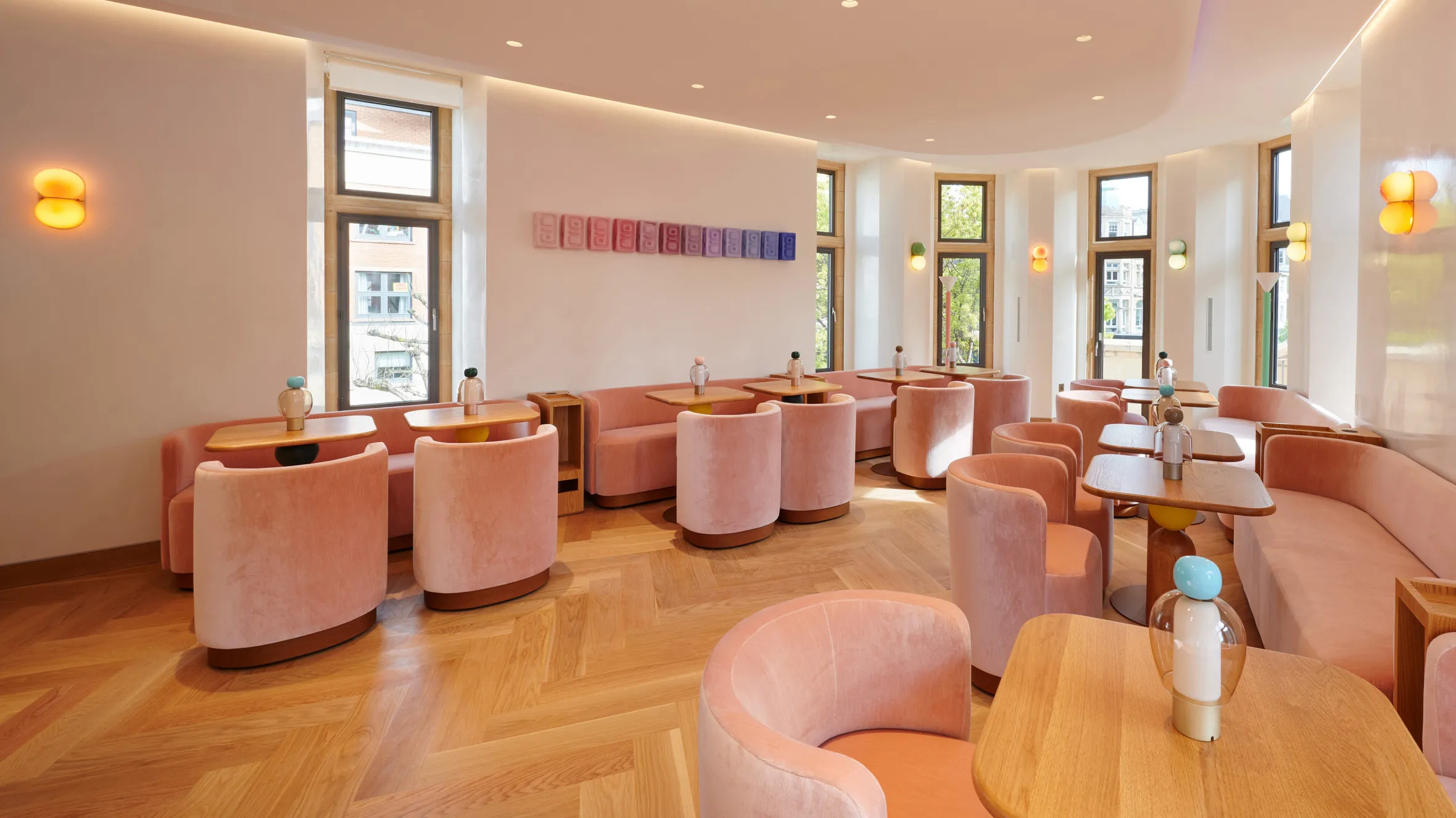 The Method Club, a cafe with peach-colored seating, light wooden tables, and large windows.