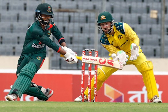 Towhid Hridoy sweeps on his way to 83 for Bangladesh as Australian captain Josh Inglis tries to gather the ball.