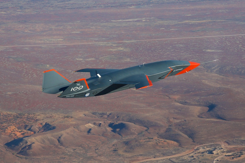 A drone that looks like an aeroplane flies through the air.