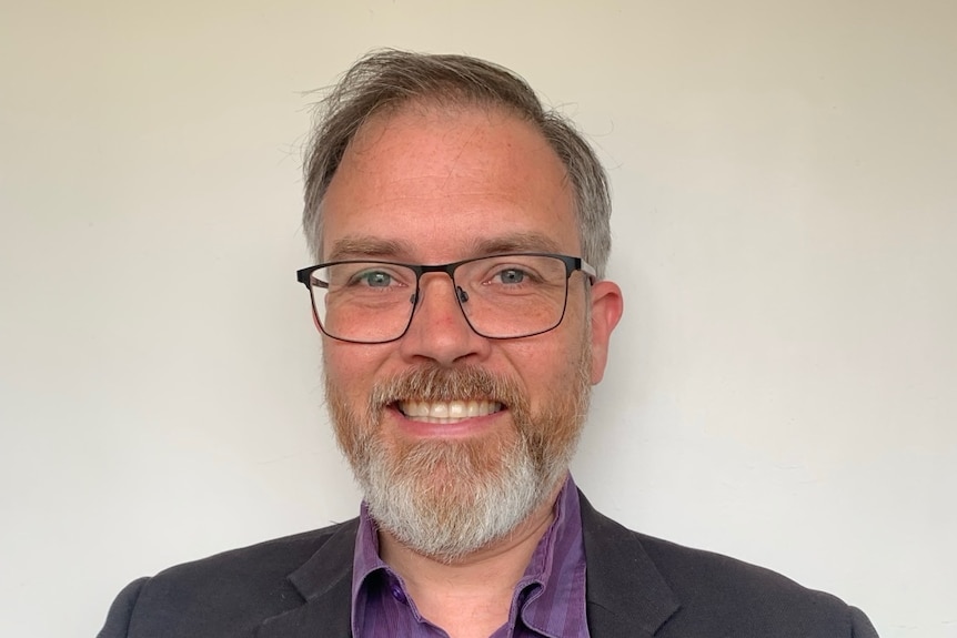 Man with a beard and glasses.