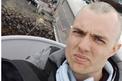 A selfie of a man in the crow's nest of a boat, while it is at port.